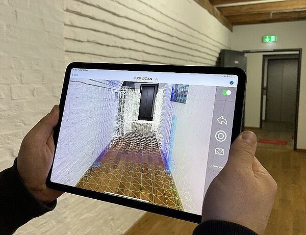 Measuring hallway digitally with measurement app, view of a tablet including mesh