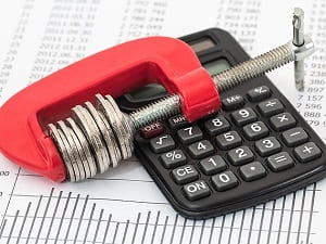 Imagen de ejemplo Reducción de costes: calculadora y pinza de tornillo con monedas
